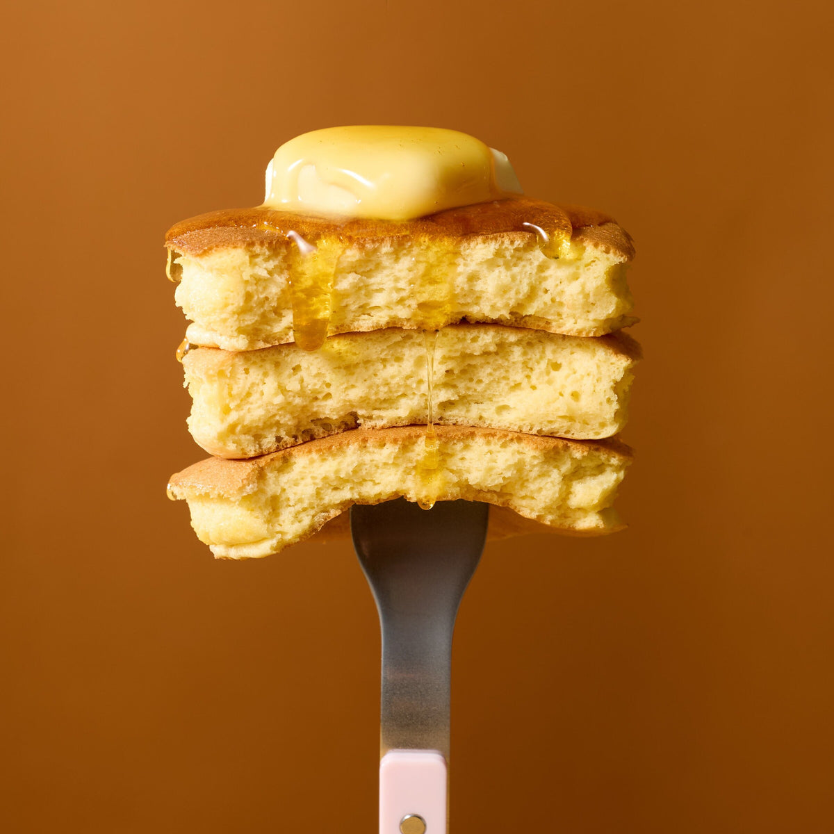 Forkful of stacked mochi pancakes with melting butter