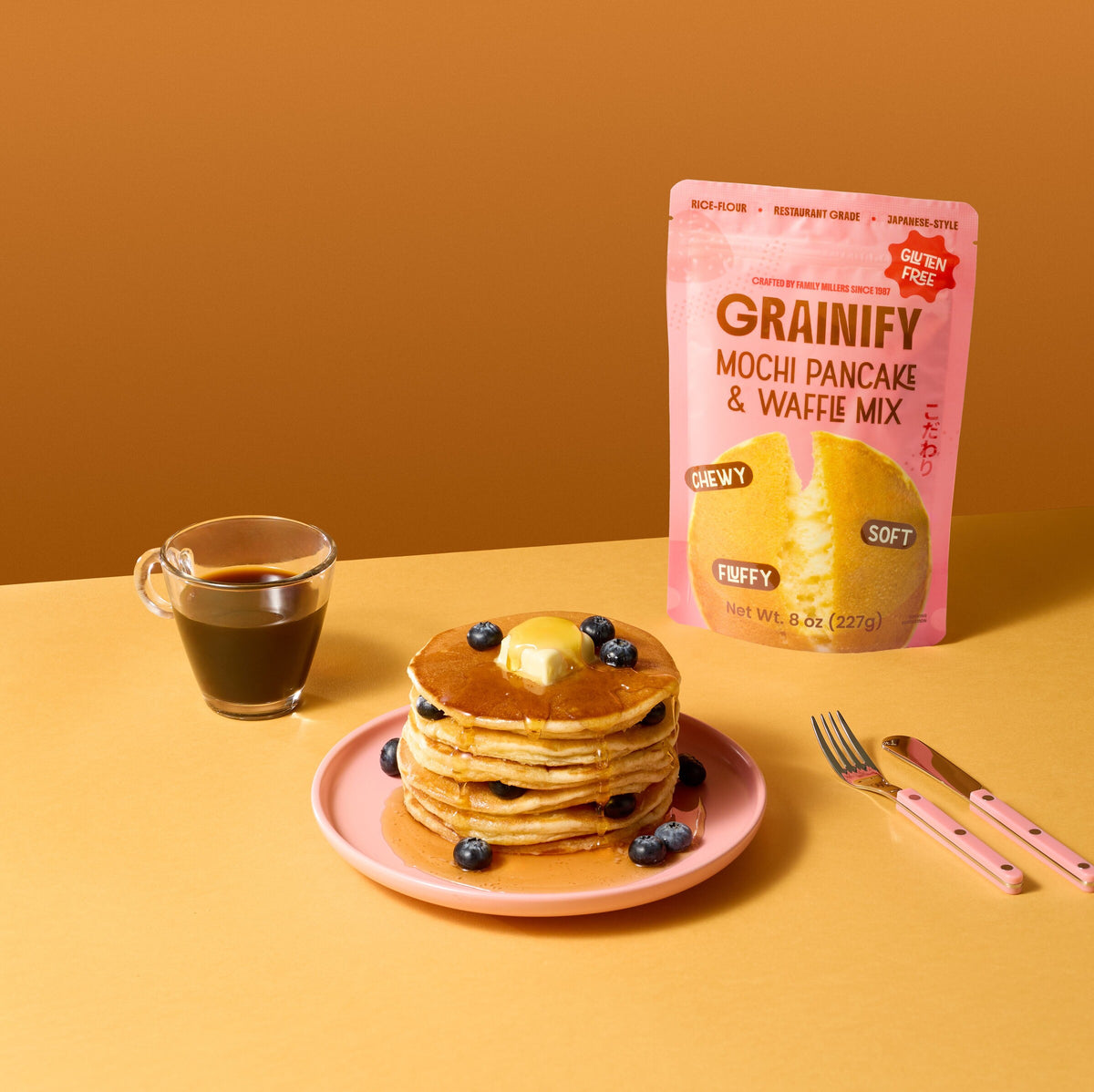 Grainify Mochi Pancake & Waffle Mix pouch with a stack of blueberry pancakes and coffee
