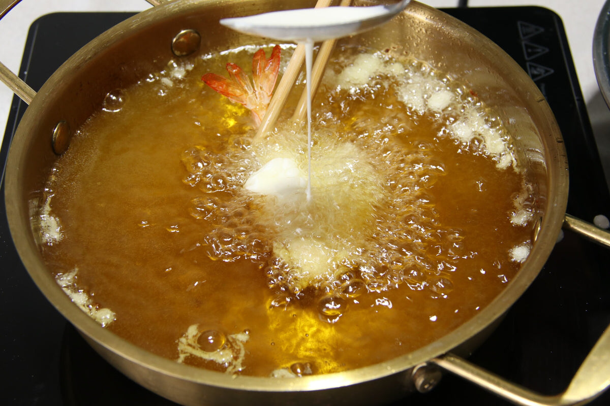 Frying gluten-free tempura shrimp in a pot of hot oil